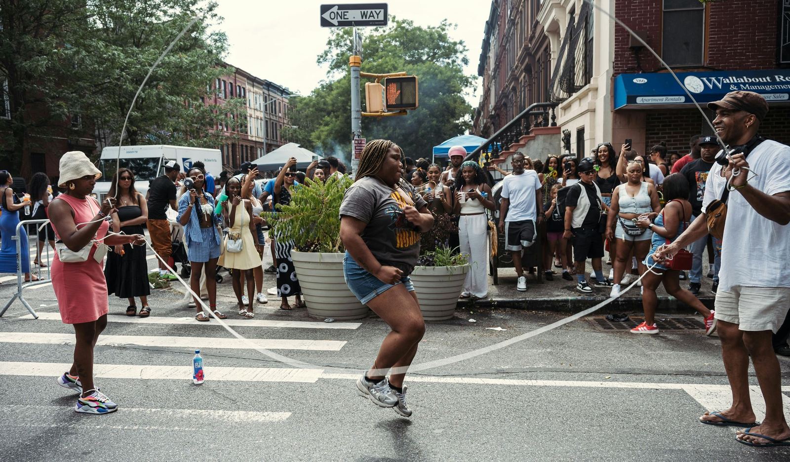 People gathering around a street performance at a neighborhood block party.